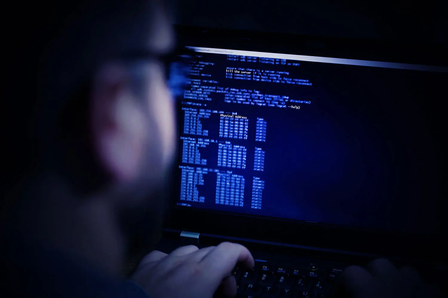 An image showing a man involved in computer hacking.